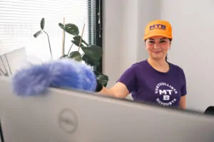 MTB työntekijä pyyhkii pölyt tietokonenäytöltä